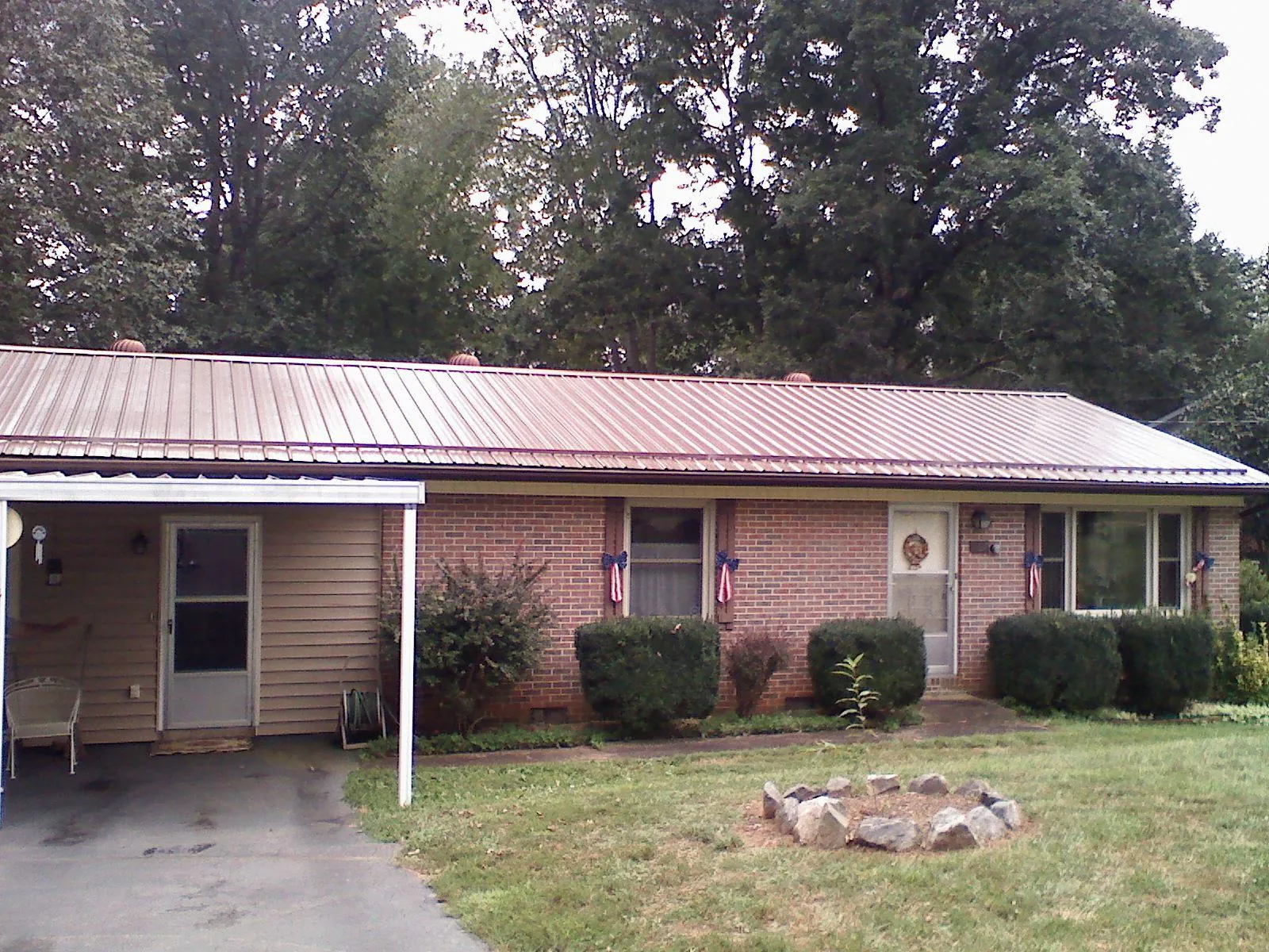 Bronze metal roof and carport on a brick ranch home — Roof Repair work by our crew in Buffalo